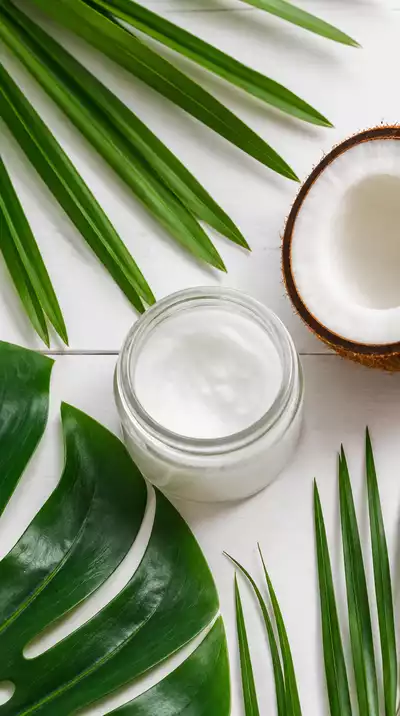 Coconut oil in a jar with tropical leaves